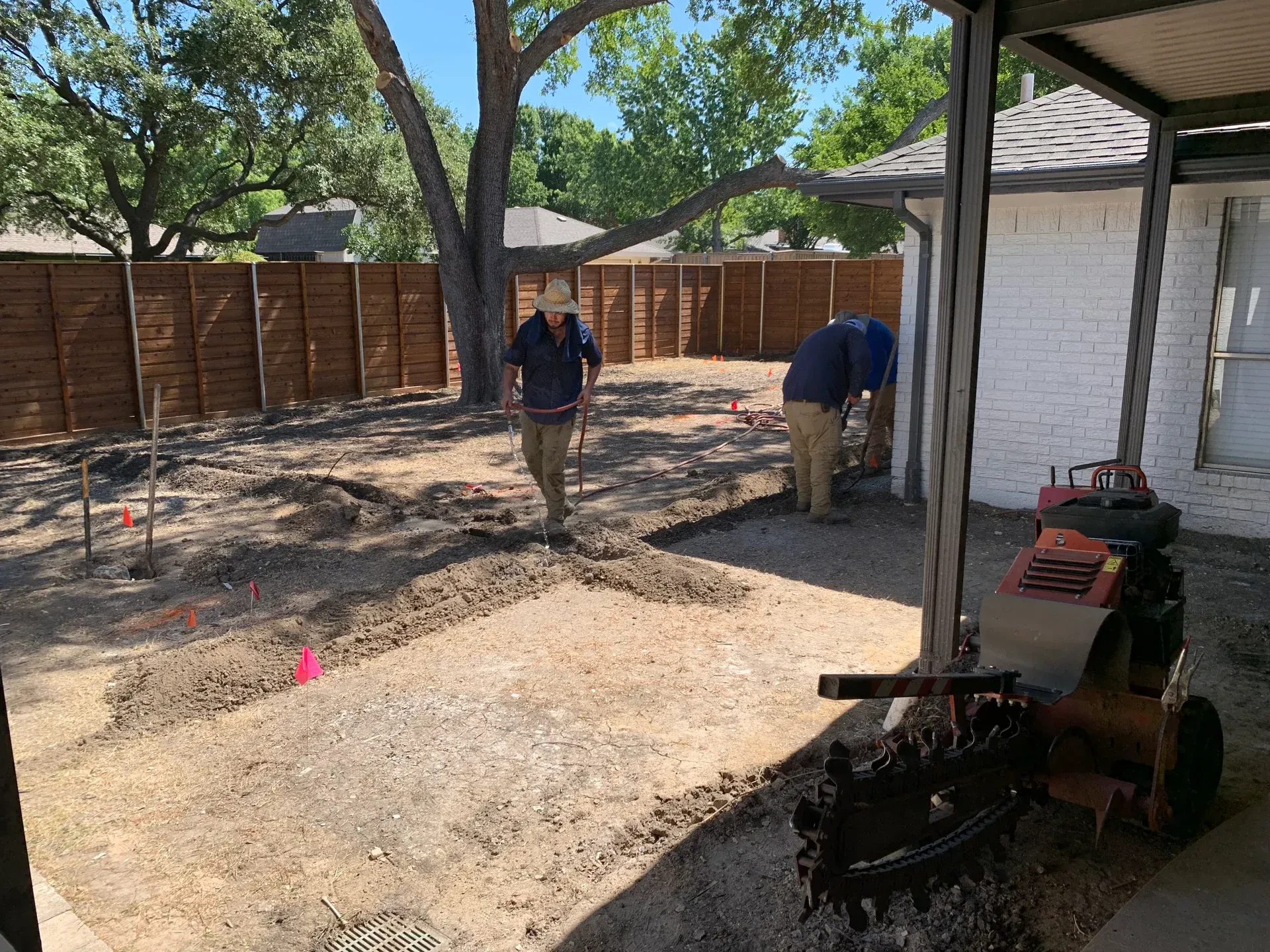 crew working in backyard beneath trees