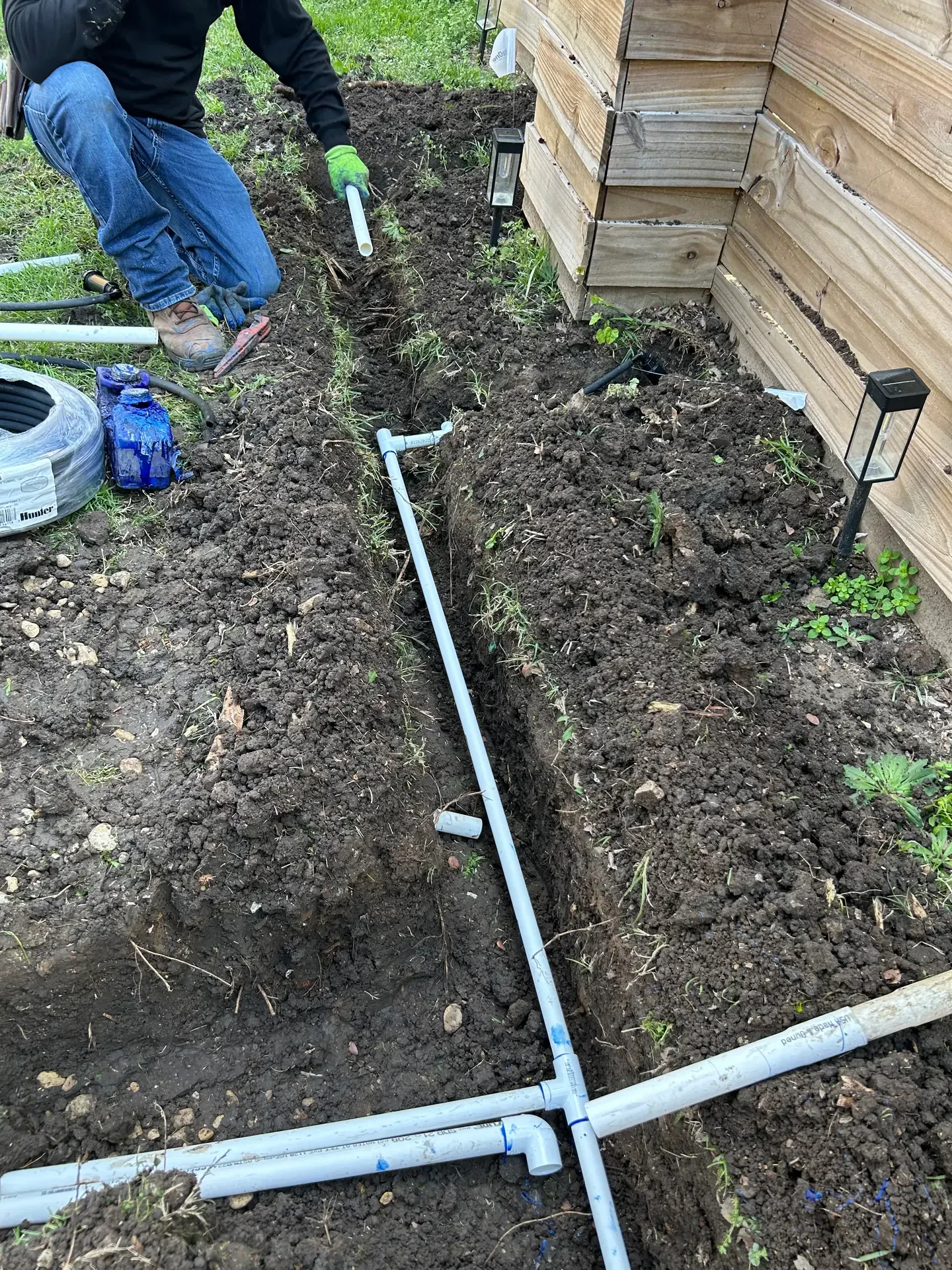 white pipe junction in side yard trench