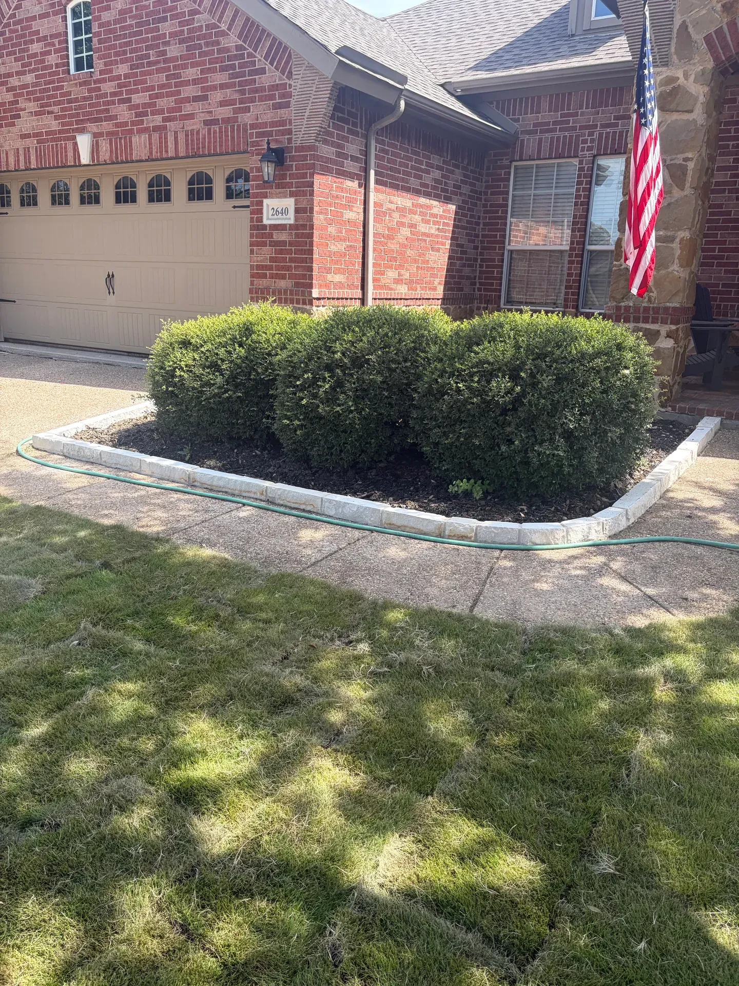 stone border beneath clipped hedges