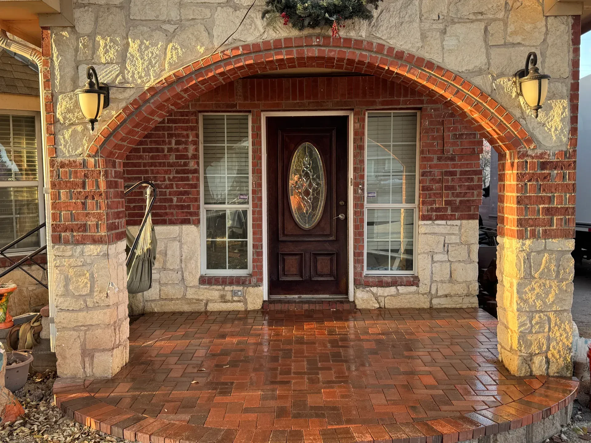 Finished brick paver porch beneath an arched front entry