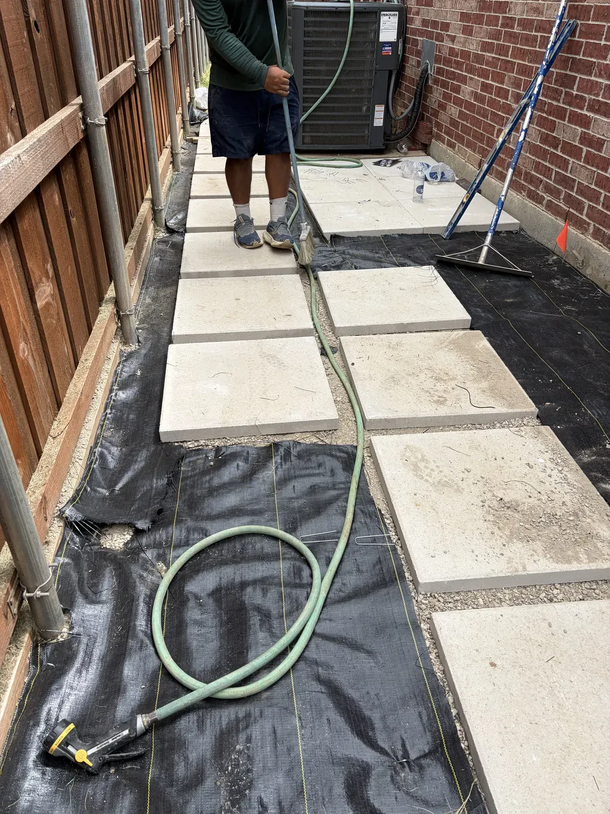 Crew spacing concrete pavers over landscape fabric